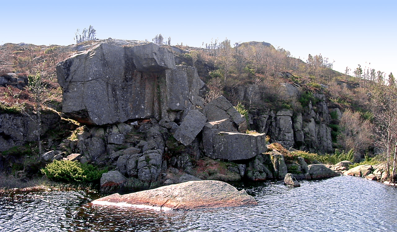 Mysinghålå sett fra andre siden av det lille vannet ved stedet. Inngangen er midt i bildet, under den store steinblokka.